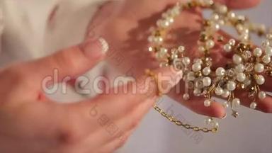 新娘手里拿着一条项链。 新娘手里拿着一条带钻石的漂亮项链
